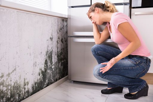 woman sees mold on wall